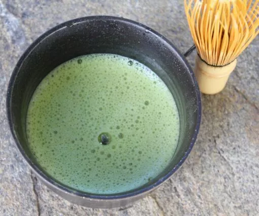 Dégustation d'un matcha dans un bol noir